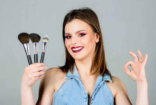 Ok Geste. sinnliche Frau mit langen Haaren, Stil. Friseursalon. Lippenstift und Lidschatten. Sexualität. Kosmetik für die Haut. Mode Make-up Visage. sexy Frau mit professionellem Make-up Pinsel — Stockfoto