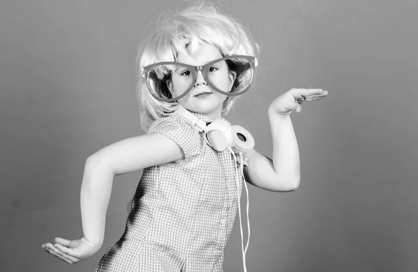 Lindo niño con auriculares fondo azul. Auriculares de niña pequeña peluca rosa bailando. Niño usando la tecnología para divertirse. Auriculares modernos. Danza de movimiento de energía. Inspirado en la música. Pequeño niño escuchando música — Foto de Stock