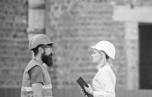 Relaties bouw client en deelnemer bouwindustrie. Bespreken voortgang plan. Industrie bouwconcept. Vrouw ingenieur en bebaarde brute builder bespreken voortgang van de bouw — Stockfoto