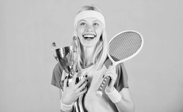 Primo posto. Risultati sportivi. Festeggia la vittoria. Campione di tennis. Ragazza atletica tenere racchetta da tennis e calice d'oro. Vincere una partita di tennis. Il tennista vince il campionato. Donna indossare abbigliamento sportivo — Foto Stock