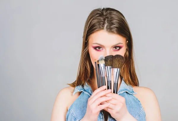 Cepillos diferentes. Cuidado de la piel. Maquillaje concepto de cosméticos. Ocultador de tono de piel. Tienda de cosméticos. Chica aplicar sombras de ojos. Mujer aplicando cepillo de maquillaje. Enfatiza la feminidad. Maquillaje profesional suministros —  Fotos de Stock