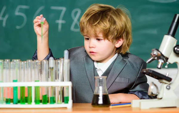 Erforschung biologischer Moleküle. Kleinkind Genie Baby. Junge in der Nähe von Mikroskop und Reagenzgläsern im Klassenzimmer. Technologie und Wissenschaftskonzept. Kinder studieren in der Schule Biologie und Chemie. Schulbildung — Stockfoto