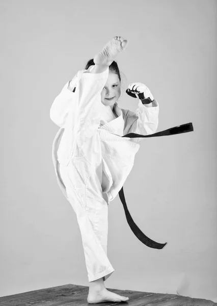 Ona jest niebezpieczna. Dziewczynka w białym kimono z paskiem. Wojownik karate gotowy do walki. Koncepcja sportu karate. Umiejętności samoobrony. Karate daje poczucie pewności siebie. Silny i pewny siebie dzieciak. — Zdjęcie stockowe