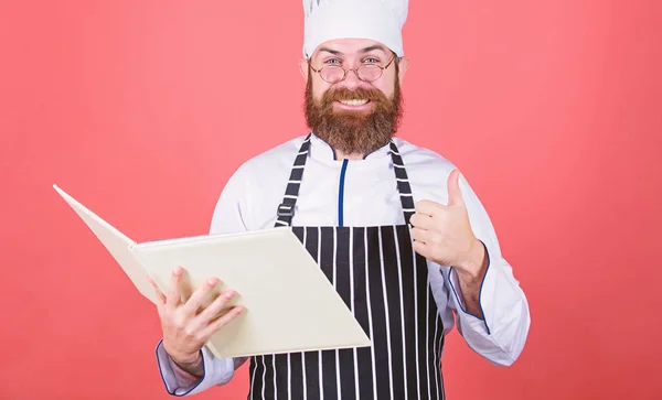 Kochen im Kopf. Verbessern Sie Ihre Kochkünste. Buchrezepte. Nach Rezept. Ein bärtiger Koch kocht Essen. Kulinarisches Konzept. Hobbyköchin liest Buchrezepte. Der Mensch lernt Rezept. Probieren Sie etwas Neues aus — Stockfoto