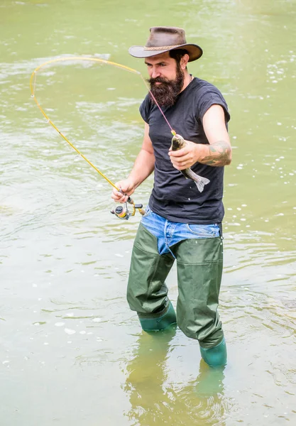 Bay avventure di pesca. weekend estivo. Pesca a mosca. Buon pescatore barbuto in acqua. pescatore mostrano tecnica di pesca uso canna. hobby e attività sportive. uomo maturo pesca a mosca. uomo cattura del pesce — Foto Stock