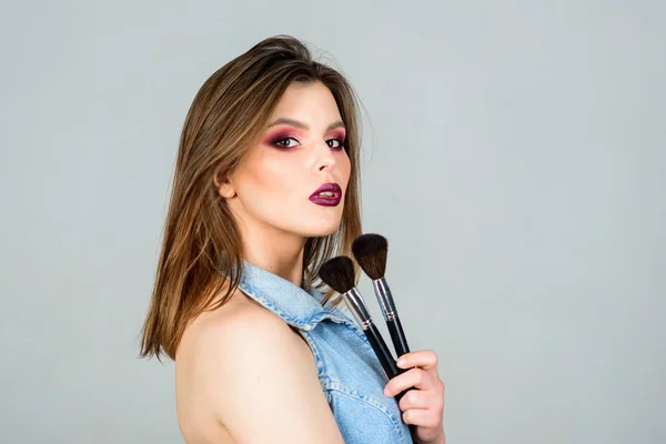 fashion makeup visage. beauty hairdresser salon. Lipstick and eyeshadow. sensual woman with long hair, style. sexuality. skincare cosmetics. sexy woman with professional make up brush. copy space