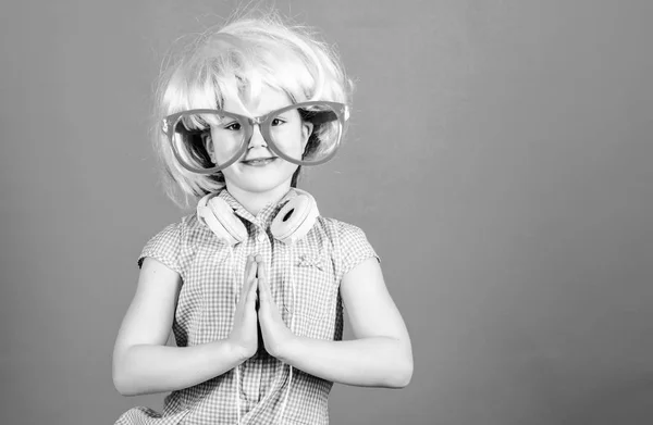 Ήρεμος και χαριτωμένος. Χαριτωμένο παιδί να σφίγγεις τα χέρια μαζί. Χαριτωμένο κοριτσάκι φορώντας ροζ περούκα και φανταχτερά γυαλιά με χειρονομία προσευχής. Αξιολάτρευτο ντίσκο DJ με χαριτωμένο βλέμμα, αντίγραφο χώρου — Φωτογραφία Αρχείου