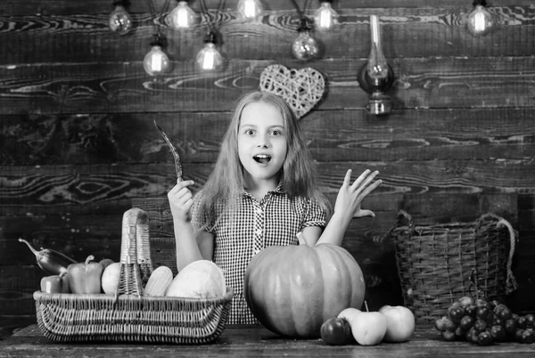 Ragazzina al mercato agricolo con raccolto autunnale. La bambina festeggia il raccolto. Coltivatore di bambini con fondo di legno raccolto. Concetto di festa agricola familiare. Fattoria giochi a tema e attività per bambini — Foto Stock