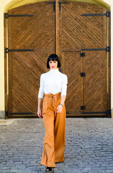 Kız makyaj yüz gevşek yüksek bel pantolon giymek. Yüksek belli pantolon moda trendi. Yüksek belli pantolon. Kadın çekici esmer moda giysiler giymek. Kadınlık ve kadınsı rakam vurgulamak