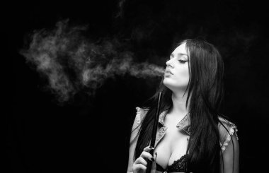 nargile barı. Elektronik sigara. Kötü alışkanlık. Kadın buharı. sağlıksız bağımlılık. Tabacco ilacı. siyah arka planda duman üfler. seksi kadın sigara puro. sigara nargile