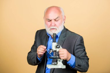 Mikroskoplu olgun adam resmi takım elbisesi. Doktora ve doktora sonrası istihdam. Moleküler biyoloji doktora projeleri. Biyoloji deneyimli öğretim görevlisi. Profesör üniversite öğretim üyesi. Bilim adamı mikrobiyolojisi