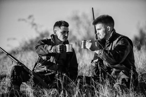 Descanse para o conceito de homens reais. Caçadores com espingardas relaxantes no ambiente da natureza. Caça com amigos lazer hobby. Caçadores amigos desfrutar de lazer. Caçadores satisfeitos com bebida de aquecimento de bebidas — Fotografia de Stock