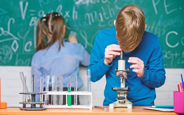 Liten pojke och flicka i lab. biologi experiment med Mikroskop. Små barn tjäna kemi i skolan lab. Kemi vetenskap. Små barn. Vetenskap. Njuta av universitetslivet — Stockfoto