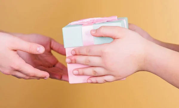 Nothing warms the heart like giving gifts to the people you love. The gift of giving. Childs hands giving a present box to mothers hands. Giving and receiving, keeping it balanced — Stock Photo, Image