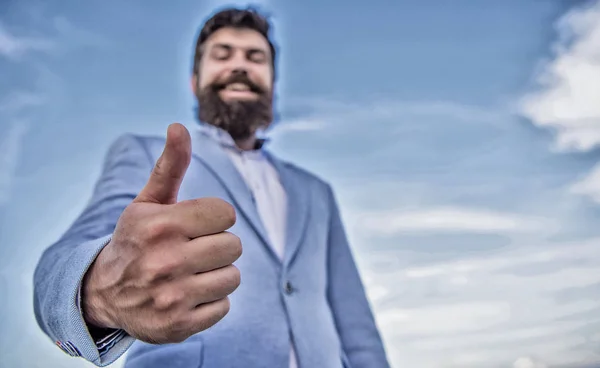 Hipster show thumbs up. Success and approval concept. Gesture expresses approval. Business approval and agreement gesture. Man cheerful bearded businessman show thumbs up sky background