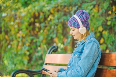 sesli kitap. stil smusic. sesli kitap ile parkta rahatlayın. mp3 çalar ile hipster kız. parkta müzik dinleyin. okumak yerine modern teknoloji. kulaklık hipster kadın. sesli kitap kavramı