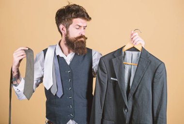 Stilist tavsiyesi. Kıyafetle eşleşen kravat. Adam sakallı hipster kravat ve resmi takım elbise tutun. Kravat seçen adam. Mükemmel kravat. Alışveriş konsepti. Mağaza asistanı veya kişisel stilist hizmeti