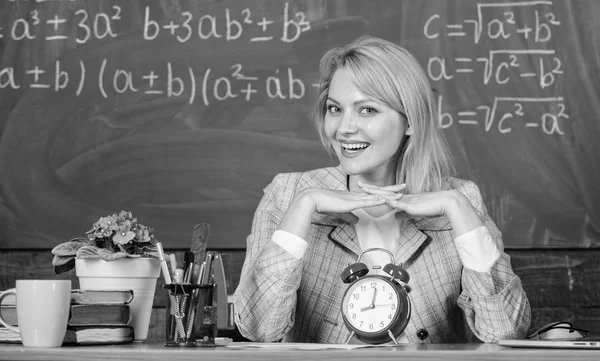 Profesor con despertador en pizarra. El tiempo. Estudio y educación. Escuela moderna. Día del conocimiento. mujer en el aula. En la escuela. Enseñanza en casa. Mujer feliz. De vuelta a la escuela. Día del maestro. Felicidad real — Foto de Stock