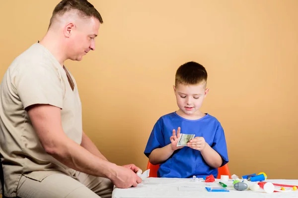 Medicine koncepció. Gyerek kis orvos Sit asztal orvosi eszközök. Egészségügyi. Orvosi vizsgálat. Kórházi munkavállaló fizetése. Fiú aranyos gyermek és apja orvosa. Orvosi segítség. Betegbiztosítás — Stock Fotó