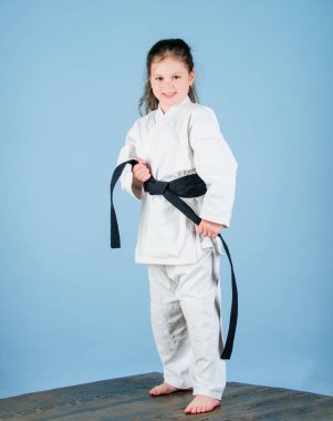 Aktivite ve spor. Karate güven hissi verir. Güçlü ve güvenilir bir çocuk. Beyaz kimono, kemer ile küçük kız çocuk. Karate savaşçısı savaşmaya hazır. Karate spor konsepti. Self savunma becerileri