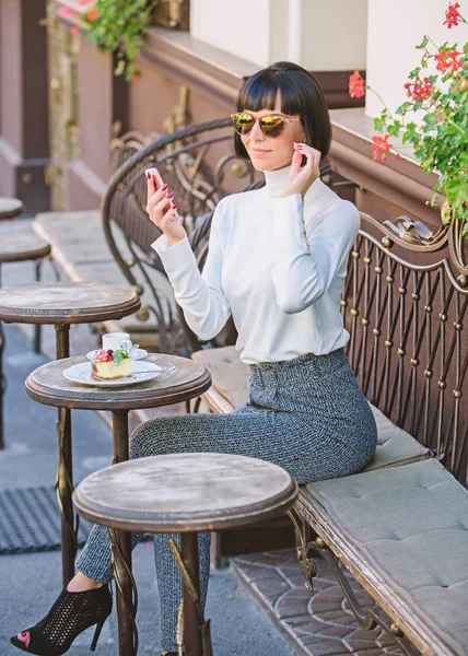 Модная девушка со смартфоном. Приятное время и досуг. Расслабься и кофе. Женщина привлекательная элегантная брюнетка провести досуг кафе терраса фоне. Звони другу. Концепция отдыха — стоковое фото
