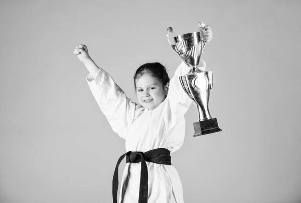 Karate fighter child. Karate sport concept. Self defence skills. Karate gives feeling of confidence. Strong and confident small kid. Victory and win. Girl little child in white kimono with belt — Stock Photo, Image