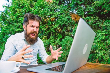 Hippi serbest çalışmakla meşgul. Karısı ve dizüstü bilgisayarı. Yavaş internet rahatsız edici. Kahve iç ve daha hızlı çalış. Son teslim tarihi yaklaşıyor. Sakallı, serbest çalışan bir adam. Uzaktan kumanda. Serbest meslek mesleği