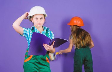 küçük kızlar atölye birlikte tamir. İş günü. 1 Mayıs. Mühendislik fikri. Geleceğin kariyeri. Tablet ve silindir ile kask küçük çocuklar. Foreman müfettişi. Onarım. bir kariyer seçimi. en iyi kariyer