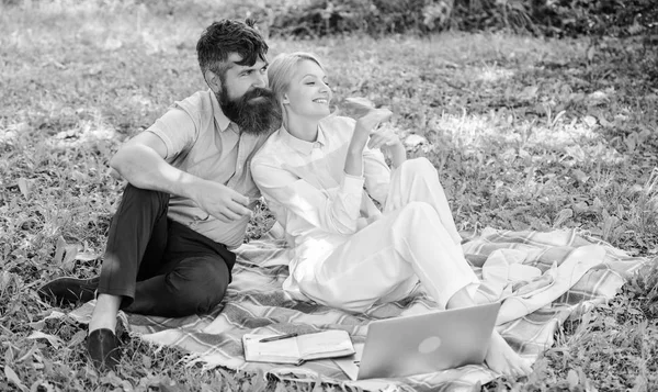 Familie genießen entspannte Natur Hintergrund. Ein bärtiger Mann und eine blonde Frau entspannen in der Natur, während sie auf einer grünen Graswiese sitzen. Paar mit Laptop entspannen natürliche Umgebung. Entspannungs- und Inspirationskonzept — Stockfoto