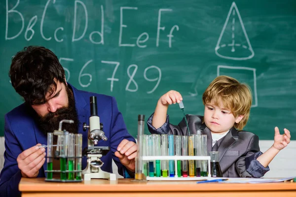 Wissen ist köstlich. Schulkind Wissenschaftler studiert Naturwissenschaften. Lehrer mit kleinem Jungen. zurück zur Schule. Vater und Sohn in der Schule. Kleines Kind lernt Chemie im Schullabor — Stockfoto