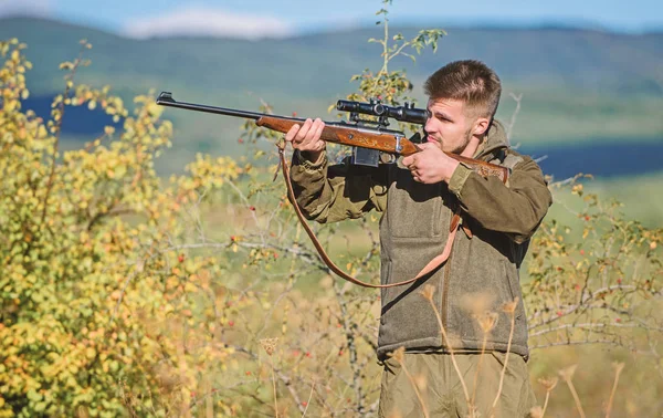 Hunter hold rifle. Hunting permit. Bearded hunter spend leisure hunting. Hunting equipment for professionals. Hunting is brutal masculine hobby. Man aiming target nature background. Aiming skills