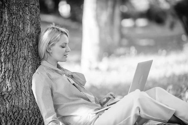 Natural environment office. Work outdoors benefits. Education technology and internet concept. Woman with laptop computer work outdoors lean on tree trunk. Girl work with laptop in park sit on grass