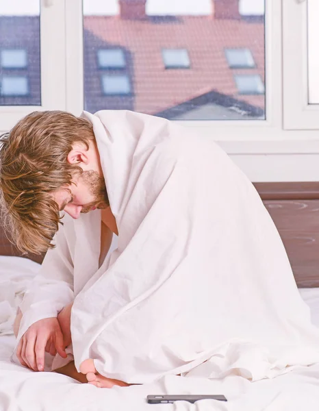 Egy fiatal férfi felébred az ágyban, és nyújtás a karját. Jóképű férfi ásítás és a nyújtás a karját felfelé. Boldog reggel. — Stock Fotó
