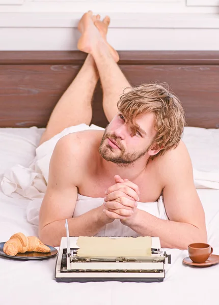 Mañana trae una nueva idea. Necesito inspiración. Creatividad crisis. Rutina diaria de escritor. Hombre escritor acostado cama con el desayuno de trabajo. Escritor guapo autor utiliza a la antigua máquina de escribir manual —  Fotos de Stock