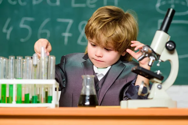 Kimyasal analiz. Çocuk, dahice bebek. Çocuk, okul sınıfında mikroskop ve test tüpleri kullanır. Bilim konsepti. Yetenekli çocuk ve nazik. Çocuk kimya okulu dersi. Okul eğitimi — Stok fotoğraf
