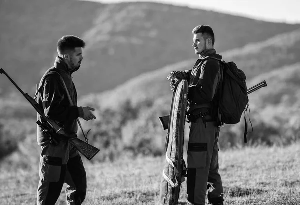 La caza con pareja proporciona una mayor medida de seguridad a menudo divertida y gratificante. Cazadores rifles naturaleza ambiente. Hunter amigo disfrutar del ocio. Cazadores amigos guardabosques caminar montañas fondo — Foto de Stock