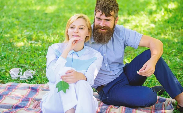 Pure nature. Couple with green leaf relax natural environment. Couple bearded man and woman enjoy nature while sit on green grass meadow. Nature beauty concept. Woman enjoy relax nature background