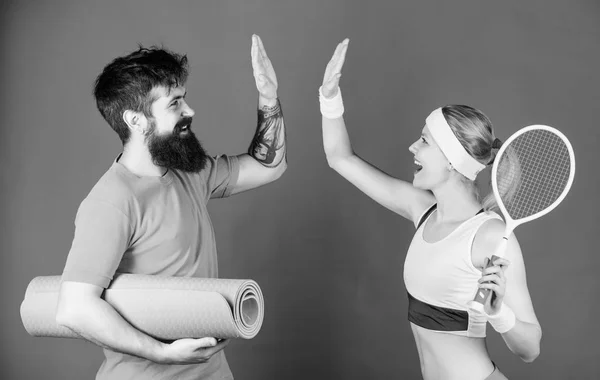 Respect All, Fear None. Athletic Success. Sport equipment. Strong muscles and body. Happy woman bearded man workout in gym. Sporty couple training with fitness mat and tennis racket. sport respect
