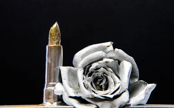 Silver metal. Silver fashion. Cosmetics and beauty supplies. Lip balm care and lipstick. Makeup concept. Fashion makeup. Metallic silver color. Metal flower and lipstick. Forging and sculpture