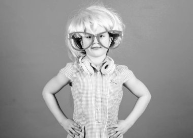 Parti çocuk olmak. Küçük çocuk saç peruk giyiyor ve kulaklıklar ile fantezi gözlük. Sevimli çocuk müzik dinlerken zevk. Parti bakmak ile sevimli küçük çocuk