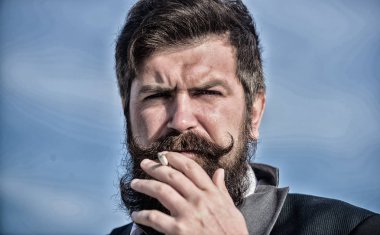 Sigara her şeyi can sıkıntısı ile öfke yönetimi için bize yardım. Sakallı bıyıklı adam sigara tutun. Sakallı hippi sigara gökyüzü arka plan sigara. Adam sigara nikotin etkisi zevk