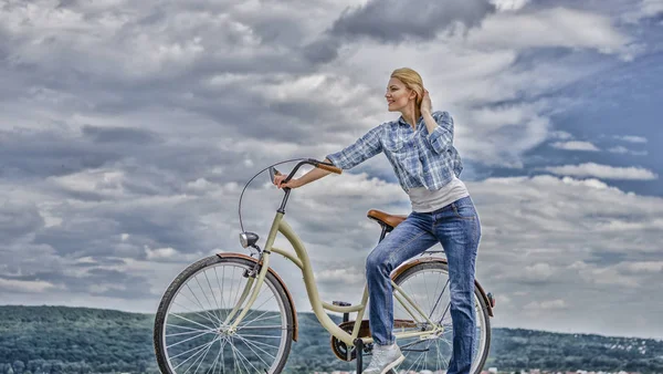 Health benefits of cycling. Woman rides bicycle sky background. Increase muscle strength and flexibility by riding bike. Benefits of cycling every day. Girl ride cruiser bicycle. Reasons to ride bike