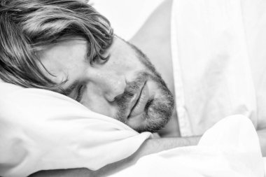 Sabah uyandıktan sonra gerin. Erkek gözleri rahatlamayla kapanır. Gözleri hala kapalı olan bir adam. Kapatmak için saatin düğmesine basıyor..