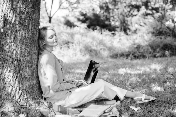 Teknologi pendidikan dan konsep internet. Kantor lingkungan alam. Bekerja di luar ruangan. Wanita dengan laptop bekerja di luar pohon ramping. Menit untuk bersantai. Gadis bekerja dengan laptop di taman duduk di rumput — Stok Foto