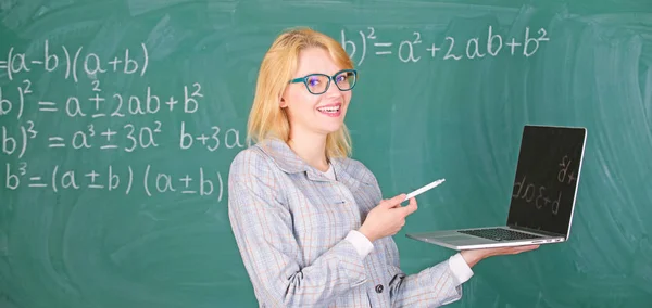デジタル技術のコンセプトです。現代のラップトップ サーフィン インターネット黒板背景を持つ教育者スマートな女性。女教師摩耗眼鏡は、インター ネット サーフィンのラップトップを保持しています。基本的な学校教育 — ストック写真
