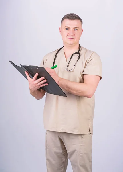 Clínica privada. Médico profesional. Médico experimentado ropa beige sobre fondo blanco. Comprueba la salud. Carrera de doctor. Hombre médico con uniforme médico estetoscopio. Medicina y asistencia sanitaria — Foto de Stock