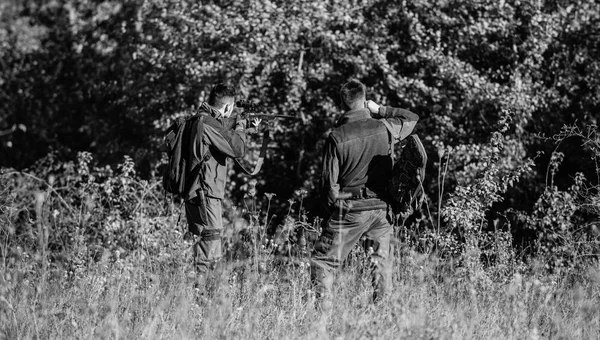 Hunting with friends. Hunters friends enjoy leisure. Teamwork and support. Activity for real men concept. Hunters with rifles in nature environment. Hunters gamekeepers looking for animal or bird