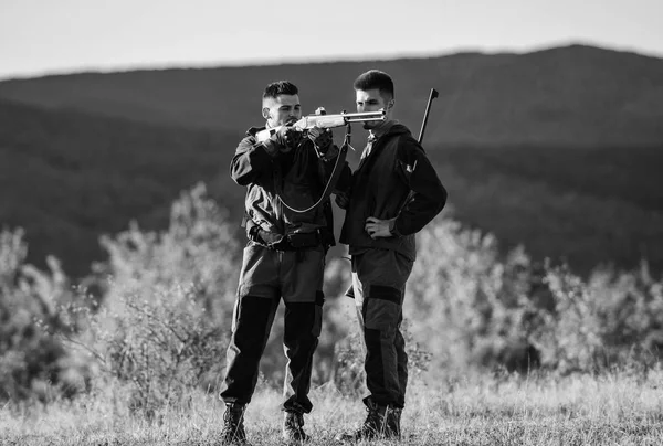 Hunting skills and weapon equipment. How turn hunting into hobby. Friendship of men hunters. Army forces. Camouflage. Military uniform fashion. Man hunters with rifle gun. Boot camp. Male with a gun