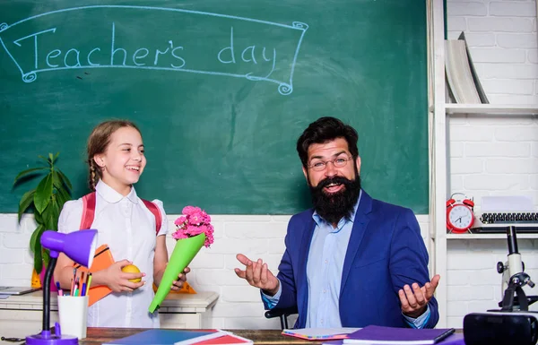 flower present for best teacher. knowledge day is 1 september. teachers day. Daugghter and father with flowers. small school girl kid with flower bouquet. back to school. Happy teachers day. wow