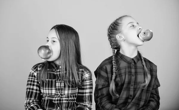 Frutas, frutas e mais frutas. Meninas comendo frutas frescas. Meninas pequenas segurando maçãs na boca. Crianças bonitas desfrutando de lanche saudável. Irmãs adoráveis tendo lanche orgânico natural — Fotografia de Stock